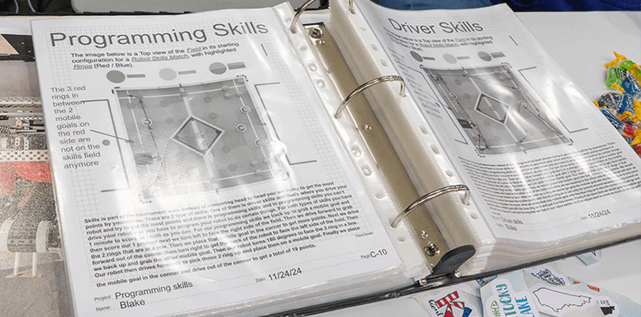 Engineering notebook on a table showcasing a team's programming skills and game strategy.