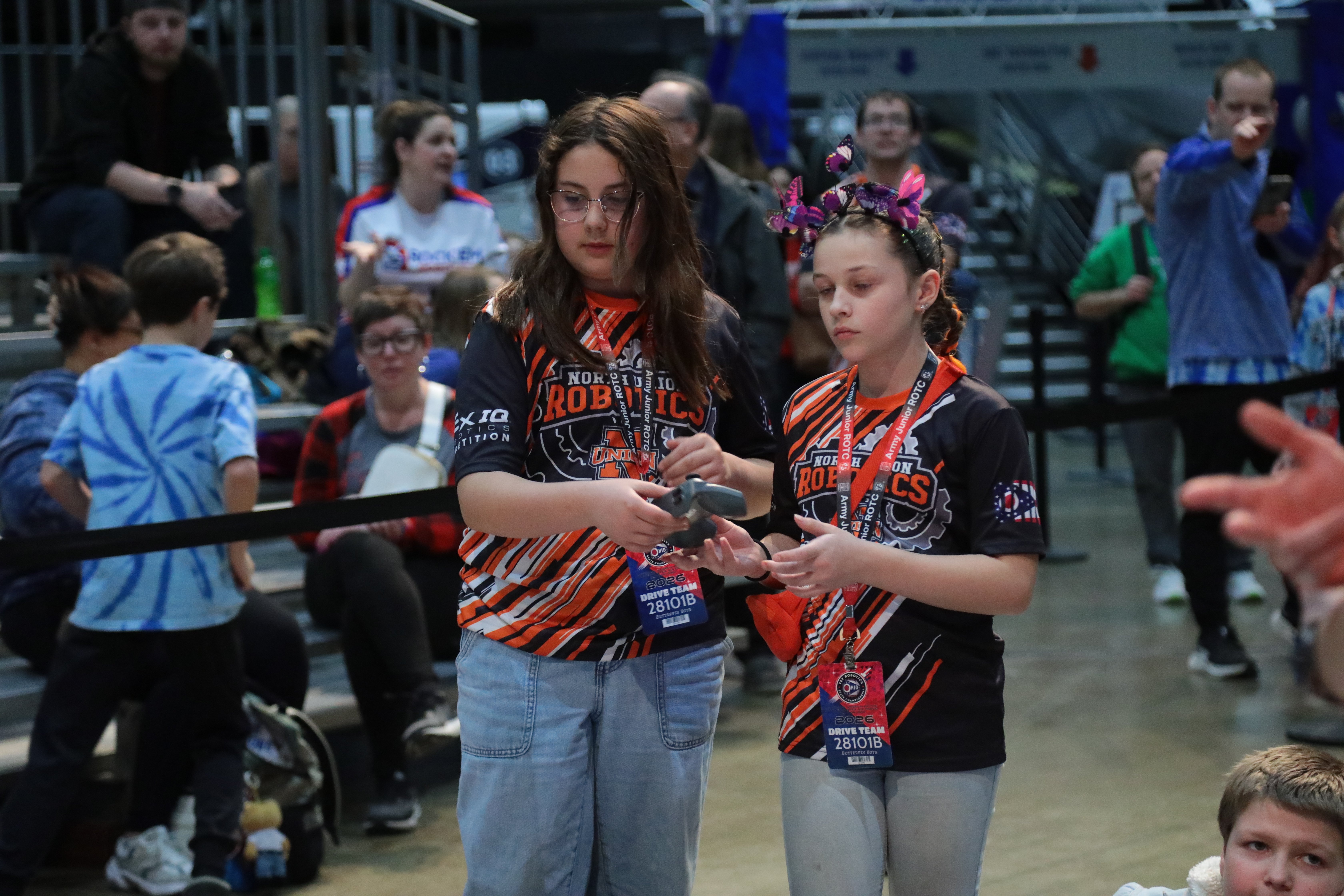 One student hands the controller to her teammate during the mid match driver switch.
