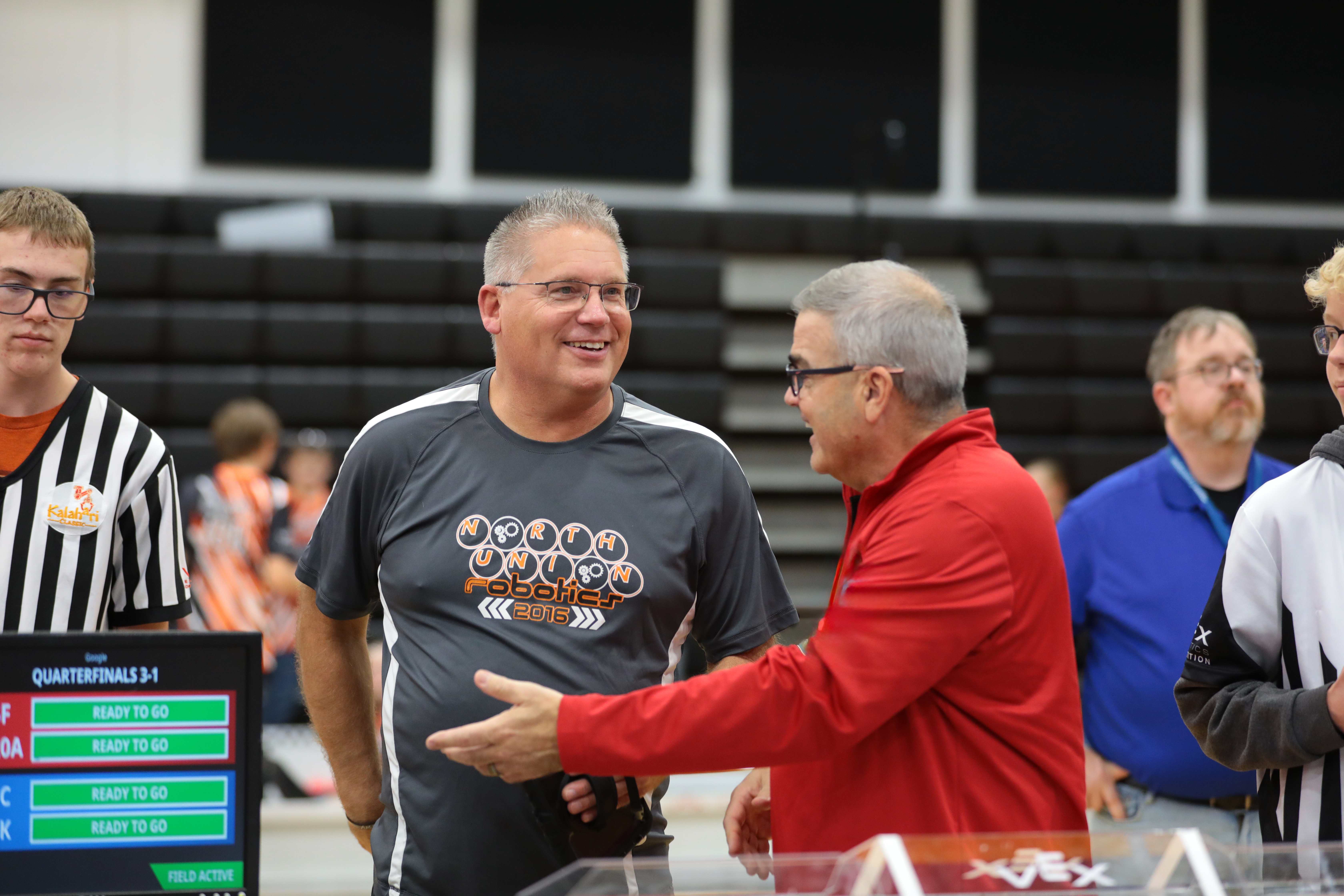 Volunteers around a competition field, with an event partner checking in, and offering a break during the day.