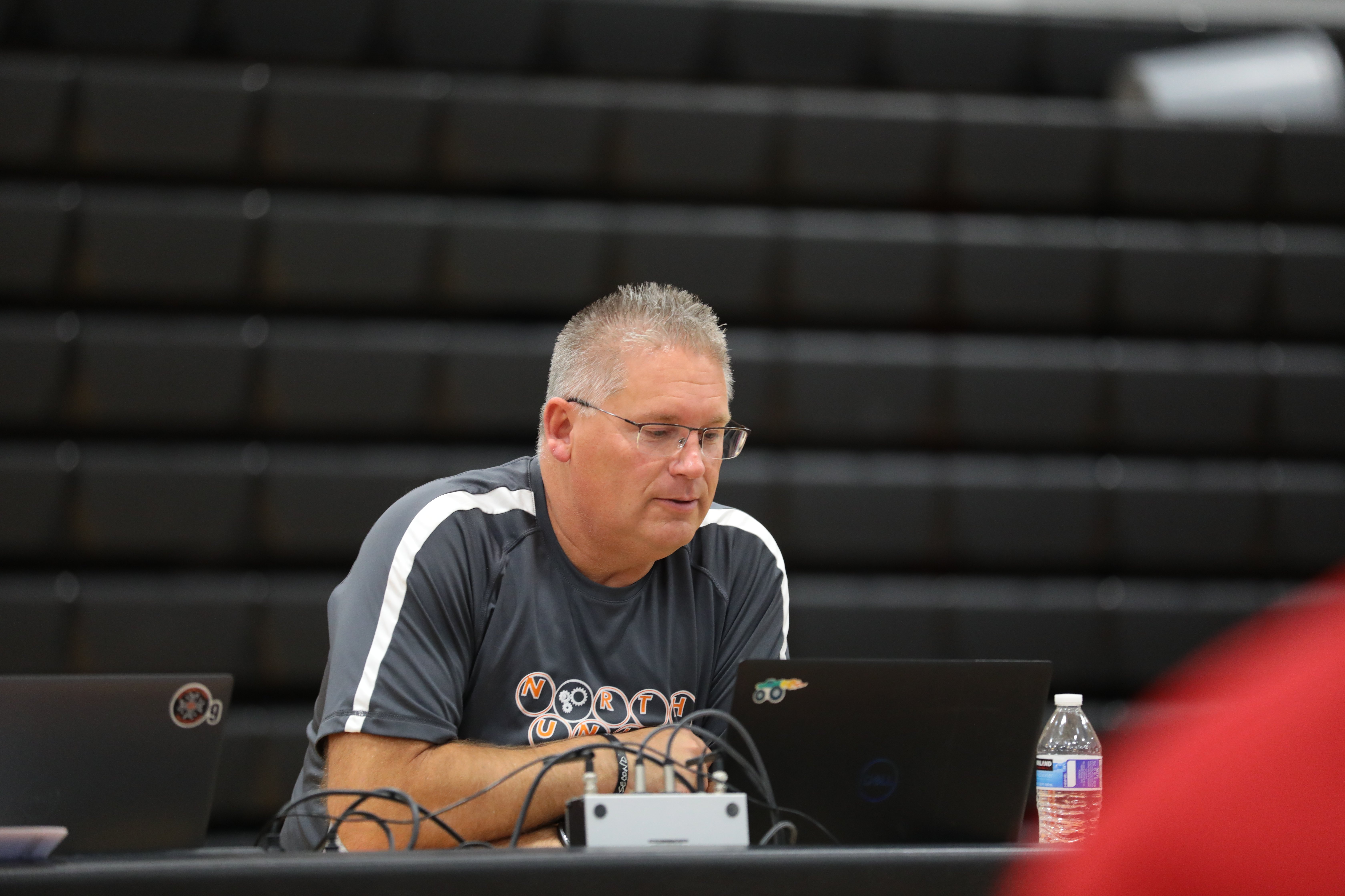 A volunteer sits at a computer checking results to finalize them at the end of an event.