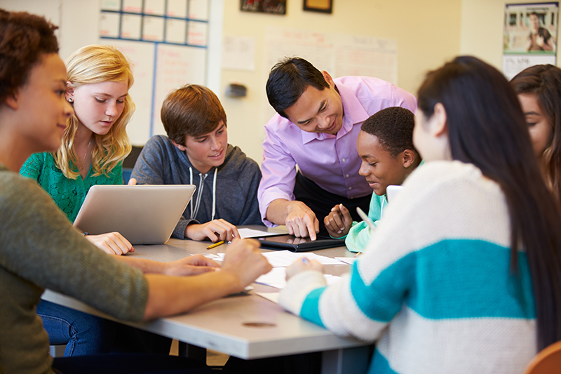 Teacher teaching in a classroom on a tablet