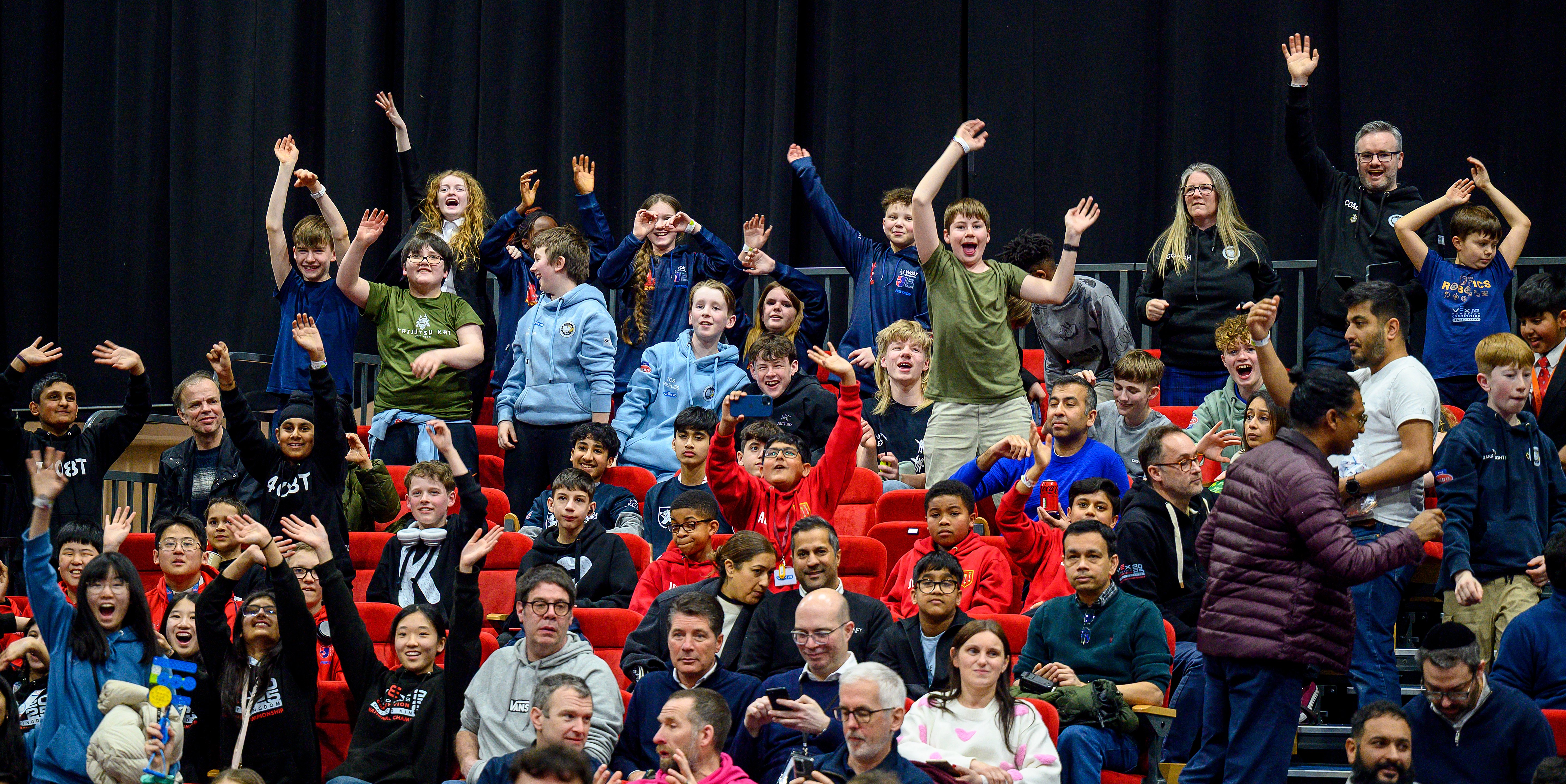 A crowd in the stands celebrating and cheering at an Awards Ceremony at the end of an event.