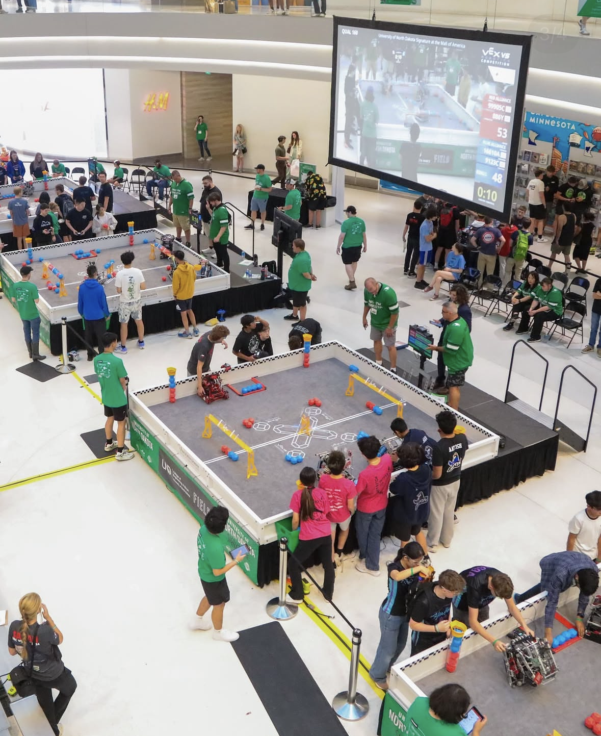 An overhead angle of a competition floor with three fields and teams competing at each field.