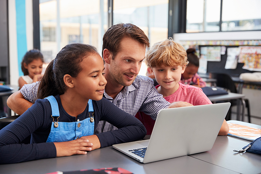 students and teacher around a computer