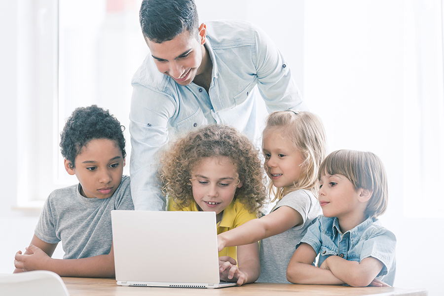 students and teacher around a computer