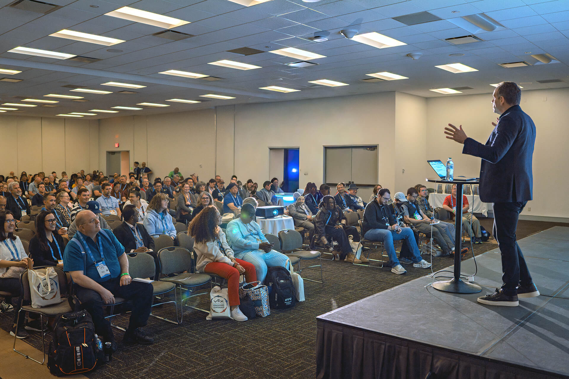 Conference attendees listening to a speaker in a presentation room.
