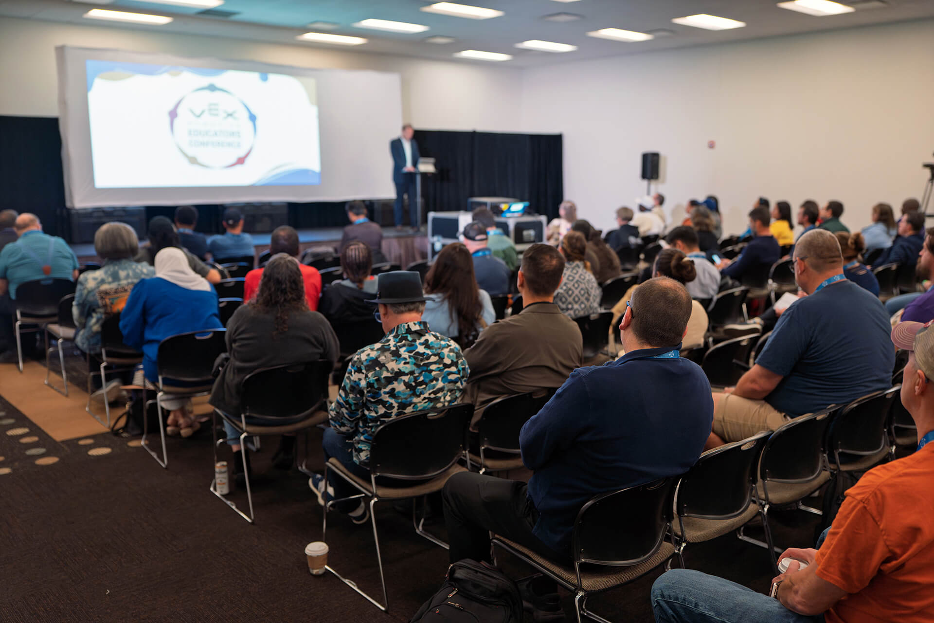 Conference participants discussing ideas during a presentation.
