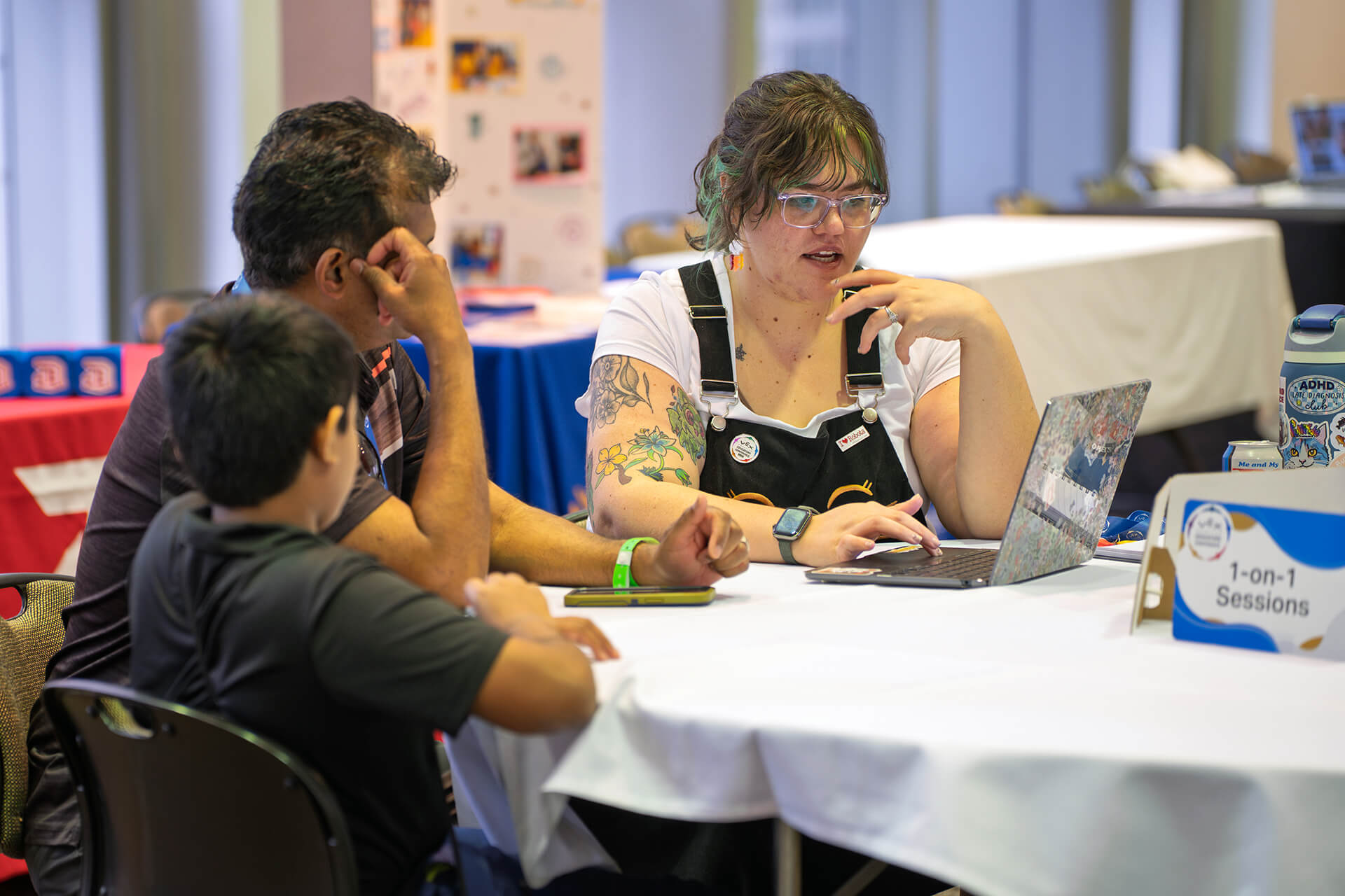 Educators using laptops and robotics equipment during a workshop.
